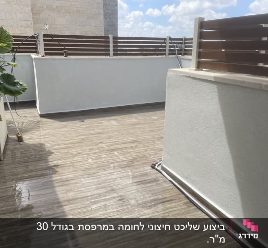 מרפסת עם רצפת עץ וצמחייה בצד